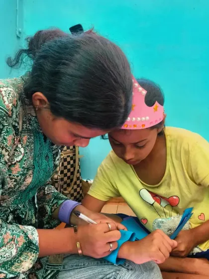 A volunteer helps a child with her craft activity after a story session. These one-on-one moments of connection are where trust and confidence are built.