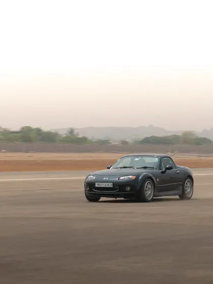 A dynamic rolling shot of a Mazda Miata from the airport run organized by Autocar India, showcasing the car's sporty profile in motion.