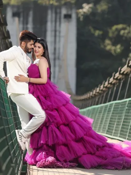 A stunning portrait on a suspension bridge in Rishikesh, with the bride's magnificent ruffled gown creating a dramatic and fashionable statement. This shot perfectly balances the couple's style with the rugged beauty of the location.
