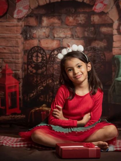 A collection of happy kids enjoying my two distinct Christmas setups: a bright, snowy winter scene and a warm, rustic brick fireplace.