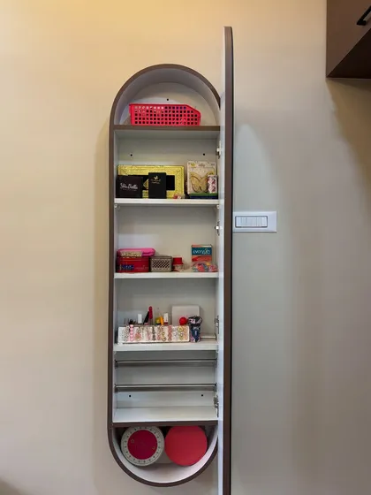 The inside of a pill-shaped dressing cabinet, showing the ample and well-organized storage space for cosmetics and accessories.