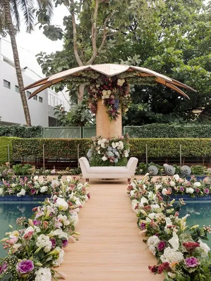 The full view of the sustainable engagement setup. The aisle, flanked by locally grown flowers, leads to a mandap with a backdrop hand-woven by women artisans. This is how we create beauty with mindfulness and purpose.