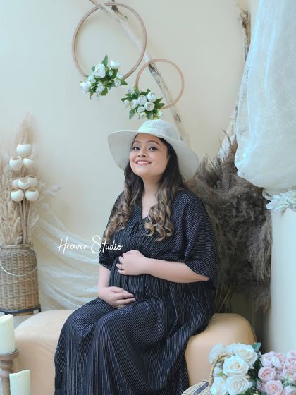 A chic and stylish portrait in a comfortable yet elegant black dress. The boho studio setup adds a warm and inviting feel to the image.