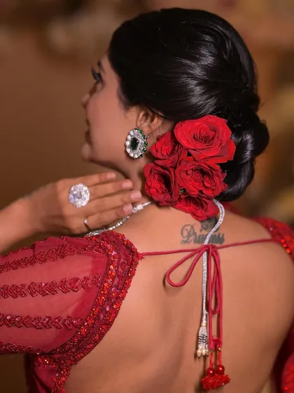 There's a shade of red for every bride. This look features a classic red rose bun, which is a timeless and romantic choice for any wedding day.
