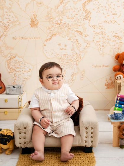 A studious little gentleman, looking very serious and cute in his glasses, ready to explore the world through books.