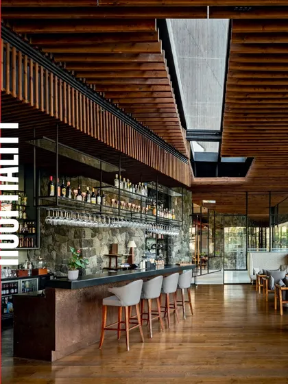The bar at the Radisson Resort is a central feature, with a stone base and extensive shelving for display, set beneath a warm, slatted wood ceiling.