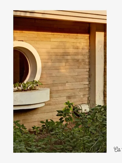 A detail from a project circa 1996, showcasing board-formed concrete texture alongside a circular window. This interplay of rough and smooth surfaces, and of rectilinear and curved geometries, adds richness to the facade.