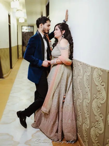 A romantic, posed shot of a couple in a hallway during their engagement party, capturing a quiet moment together.