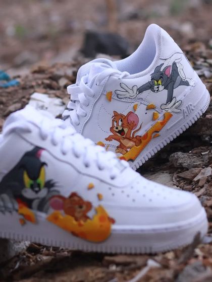 A shot of the Tom & Jerry custom sneakers on a rocky surface, giving them a rugged, playful feel.