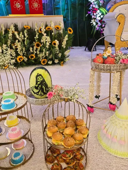 A beautiful shot of our mini food display, including mini cakes and burgers, set against a backdrop of fresh flowers and a custom watermelon carving.