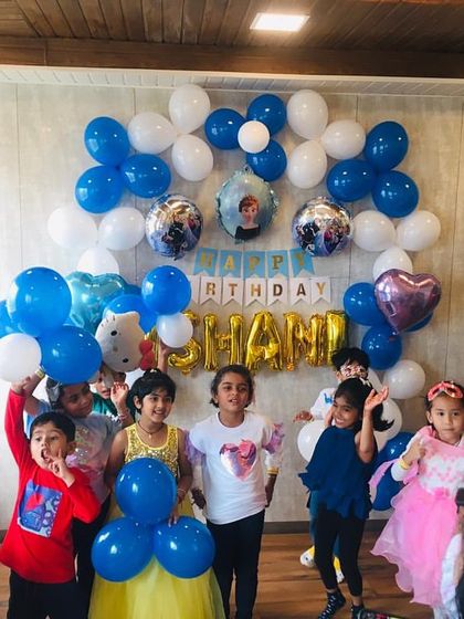 A group of happy kids gathers for a photo at a Frozen-themed birthday party. I love seeing the excitement on their faces as they celebrate with their friends in a space decorated just for them.