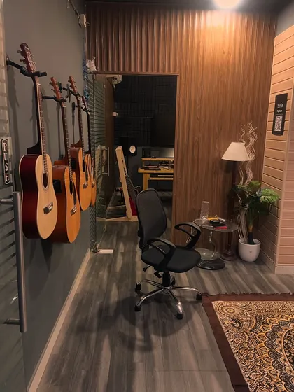 A look down the hallway of our studio, with a line of acoustic guitars ready for students to use during their lessons.