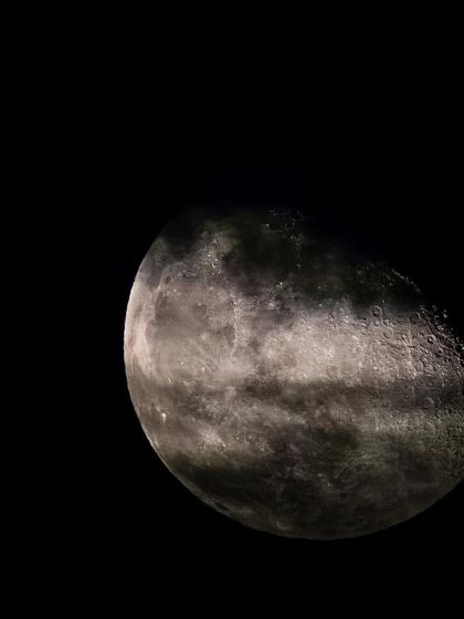 A close-up of the moon with thin clouds passing in front of it. This shot adds a layer of mystery and texture to the lunar portrait.