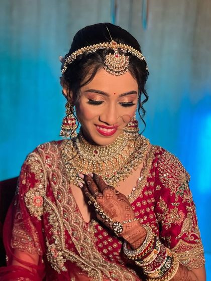 A classic bridal look featuring a gold and red toned choker set with a delicate matha patti. This rental jewellery adds a touch of royalty to any wedding outfit.