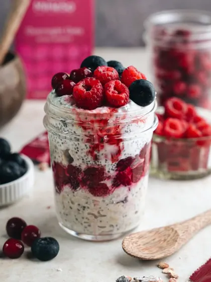 A healthy and delicious-looking jar of overnight oats with chia seeds and fresh berries. This was styled and shot for a health food brand to look like a dessert you can have for breakfast.