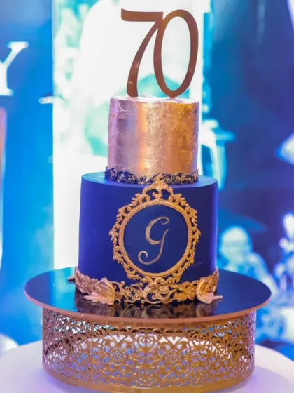 The royal blue and gold 70th birthday cake, pictured at the celebration. The pure gold foil adds a touch of true luxury.