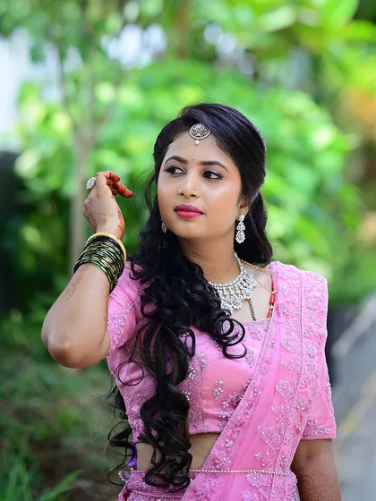 The bride posing in a beautiful garden setting, her pink lehenga standing out against the greenery.