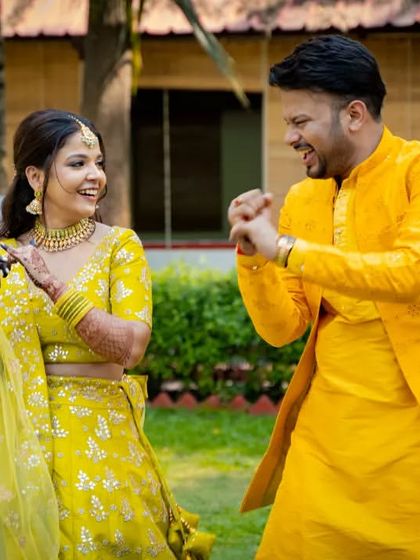 A candid photo of the couple sharing a laugh during their outdoor Haldi celebration.