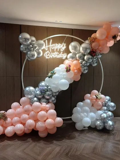 A full view of the elegant peach and silver balloon decoration, perfect for a sophisticated adult birthday.