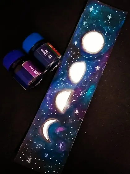 This bookmark captures the mesmerizing phases of the moon against a deep blue and purple galaxy. I painted this celestial design with watercolours, making it a wonderful gift for any book lover who enjoys stargazing.