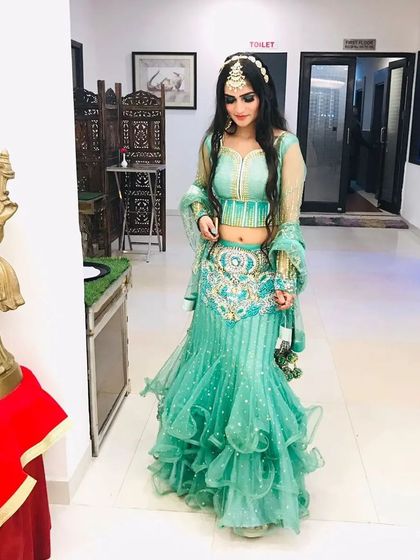 A client looking gorgeous in a sea-green ruffled mermaid lehenga, complete with hair, makeup, and jewellery from my studio.