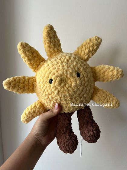 A close-up of our handmade sun plushie. The chunky yarn gives it a wonderful, tactile texture that kids love to hold and squeeze.