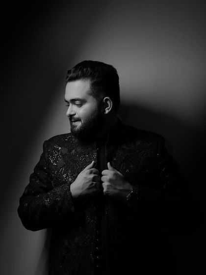 A dramatic black and white portrait of the groom, using shadows to create a powerful and classic look.