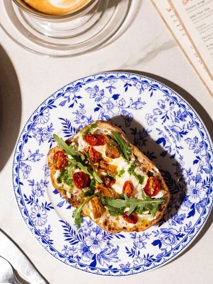 Crunchy, creamy, and perfection on a plate. Meet our Stracciatella Bruschetta, served on a beautiful blue and white floral plate.
