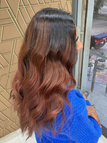 A side view of a stunning global and balayage look. The rich tones and soft waves create a truly elevated style.
