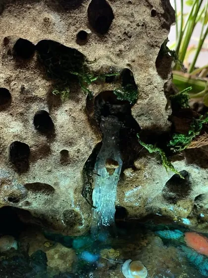 A close-up detail of the miniature waterfall I crafted from resin. I added bits of moss to the rock to give it an aged, natural look, making the water feature a central point of this tiny ecosystem.