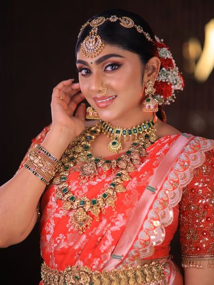 This stunning red floral saree is styled for a high-fashion bridal shoot. The drape is immaculate, designed to look dramatic and beautiful on camera.