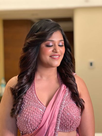 The eye makeup for this look is a soft, shimmery mauve that complements her saree perfectly. It's a beautiful example of soft glam makeup.