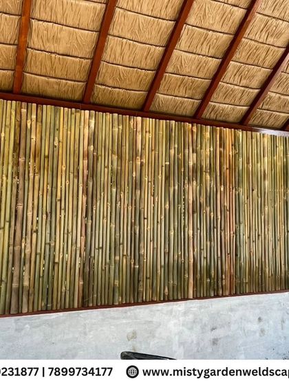 A close up of the bamboo wall and thatched roof interior of the cow shed, showing the natural textures and craftsmanship.
