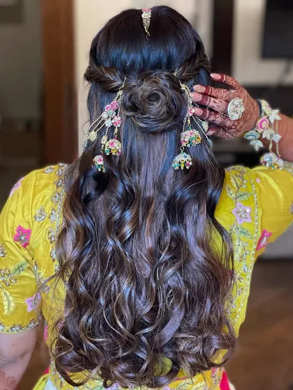 A detailed back view of the Haldi hairstyle, showing the hair rose and jhumki accessories.