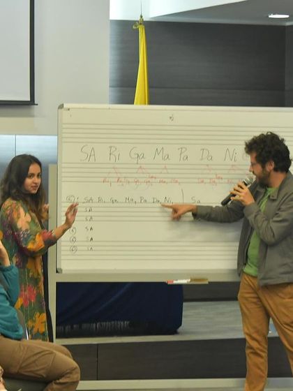 Pointing out the nuances of swara placement on the whiteboard. These details are the building blocks for creating authentic melodic expressions in Indian classical music.