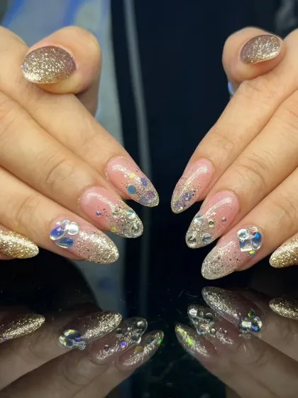 A full view of the glamorous gold glitter and rhinestone nail set.