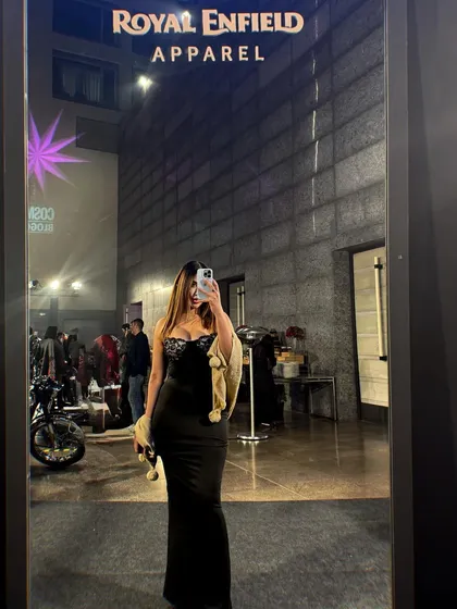 A mirror selfie at the event, showing the full length of the elegant black gown.