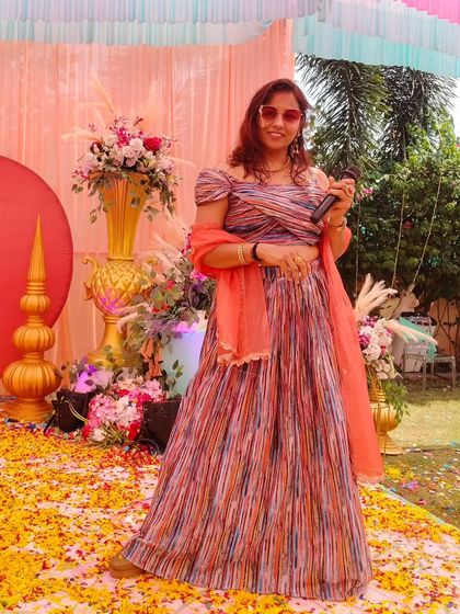 On the Haldi stage, surrounded by flower petals, ready to get the party started. This is what a celebration looks like.