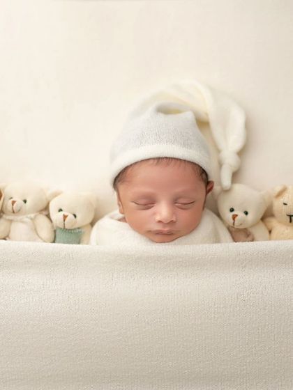 Sleeping soundly with his teddy bear friends. This classic newborn shot is always a favorite among parents.