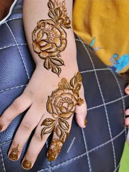 A simple yet stunning floral design on the back of the hand, showcasing clean line work. This is a great example of the elegant guest mehandi you will learn to create.