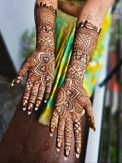 A stunning bridal design featuring a mandala on the palm and a custom city skyline on the arm.