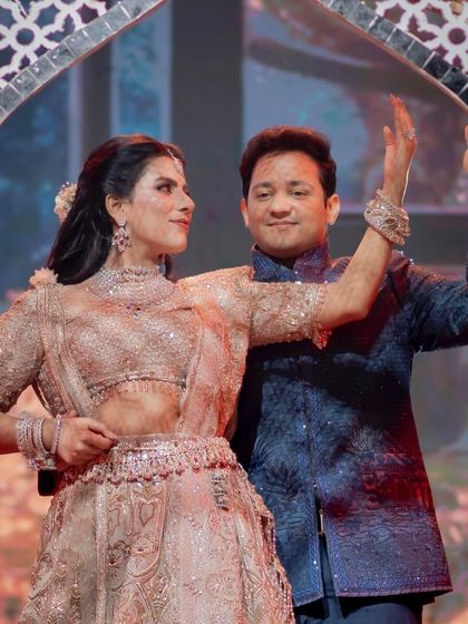 A graceful pose within a mirrored arch prop. We design choreography that interacts with the stage decor, creating stunning visual frames like this one during a couple's performance.