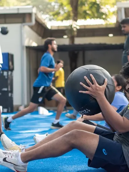 An athlete performs medicine ball sit-ups during our outdoor community workout. We believe in building a strong community around fitness.