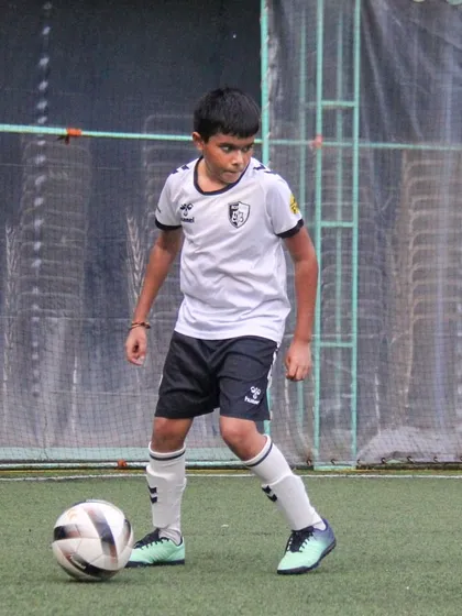 A young athlete stands over the ball, assessing his options. We teach players to think tactically and make smart decisions on the field.