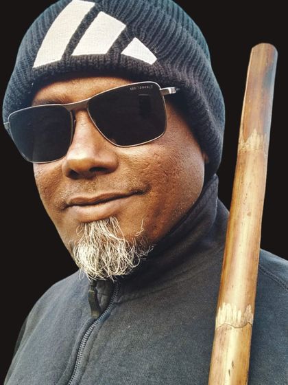 Another portrait with the Bo Staff, highlighting its natural texture and feel as a traditional training tool.