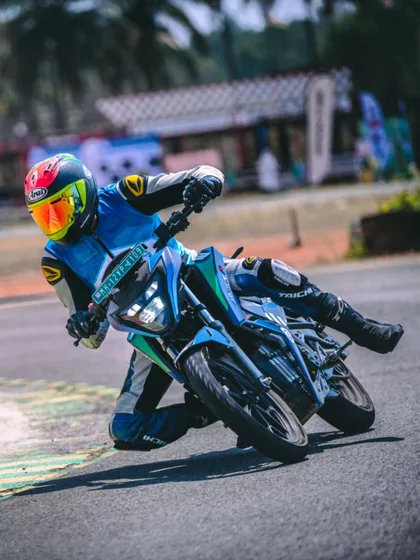 A dynamic shot of me leaning deep into a turn on an electric motorcycle. We teach riders how to trust the bike and carry momentum through the corners.