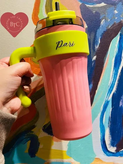 Our personalised insulated tumbler with a handle, shown here in a vibrant pink and neon yellow combination. The two way lid is leak proof and perfect for taking your beverage on the go.