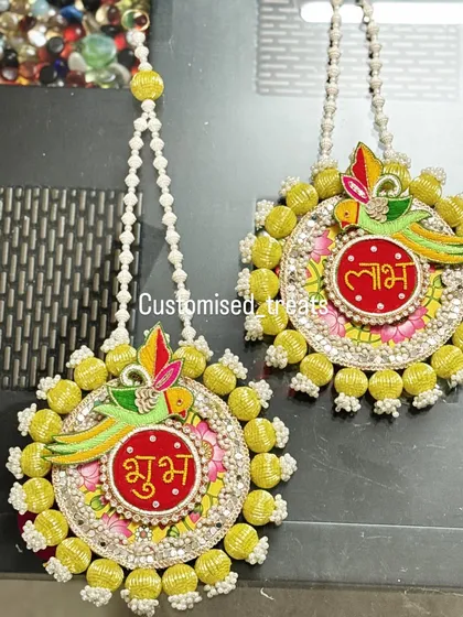 Welcome positivity into your home with these beautiful Shubh Labh hangings. The parrot motif and bright yellow beadwork make them a cheerful addition to your main door for Diwali and beyond.