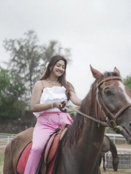 A smiling rider on horseback, demonstrating the happiness and confidence that comes from building a bond with a horse.