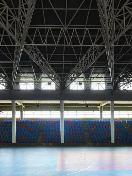 The empty seating banks of the arena highlight the scale and rhythm of the space. The design is both monumental and functional, capable of accommodating large crowds.